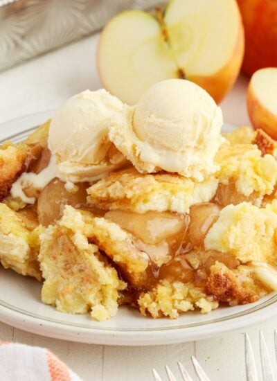 Close up of a plate of Apple Cream Cheese Dump Cake with ice cream on top.