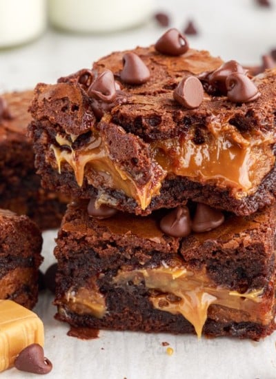 two caramel brownies stacked on top of each other