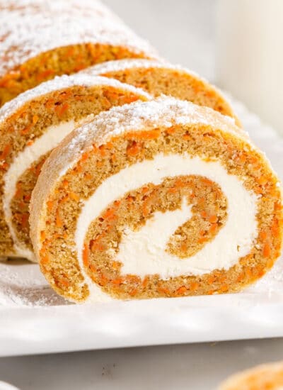 Slices of Carrot Cake Roll showing the inside roll and frosting on a platter,