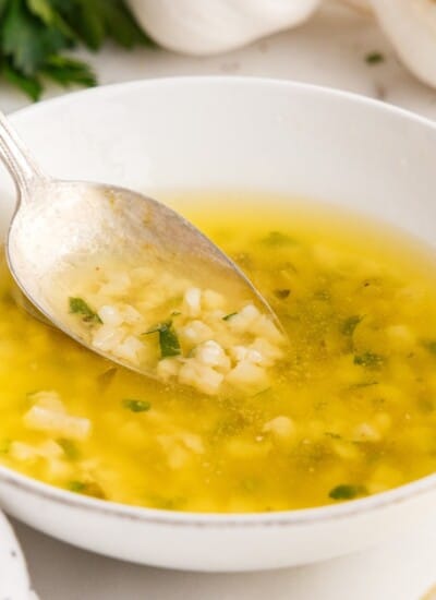A close up of Garlic Butter Sauce with a spoon inserted.