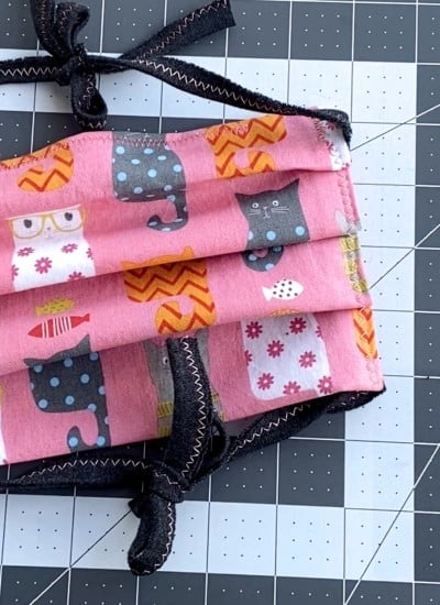Cat Pattern on pink face mask on grey and white sewing cut mat
